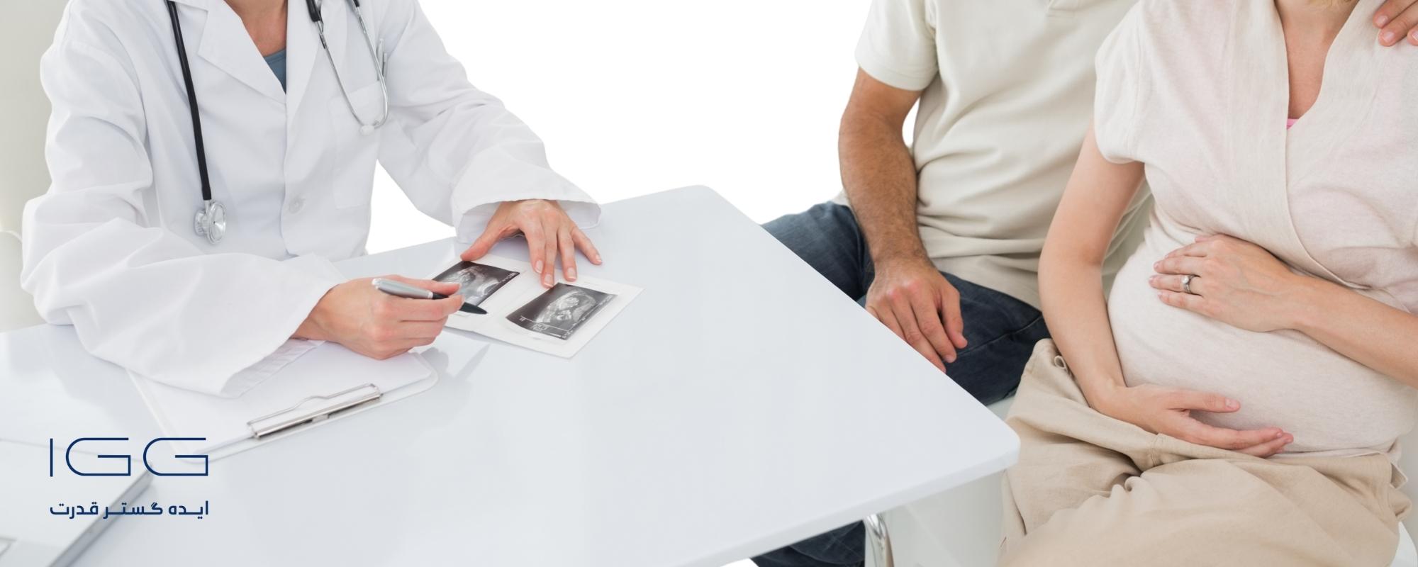 پزشک در حال توضیح تصاویر سونوگرافی جنین به والدین و بررسی روند رشد و سلامت نوزاد در دوران بارداری.